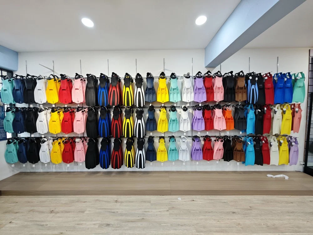 Extensive wall display of new scuba diving fins in a wide range of colors including yellow, white, blue, and red available at TDB Dive Shop.